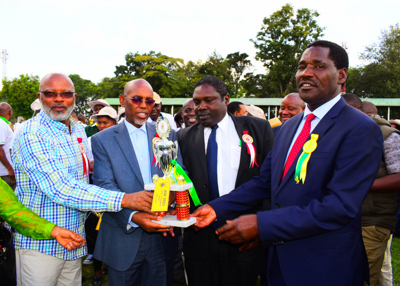 Agriculture CS Peter Munya presents an award for the junior champion heifer to ADC Directors at the ASK Nakuru National show 2022